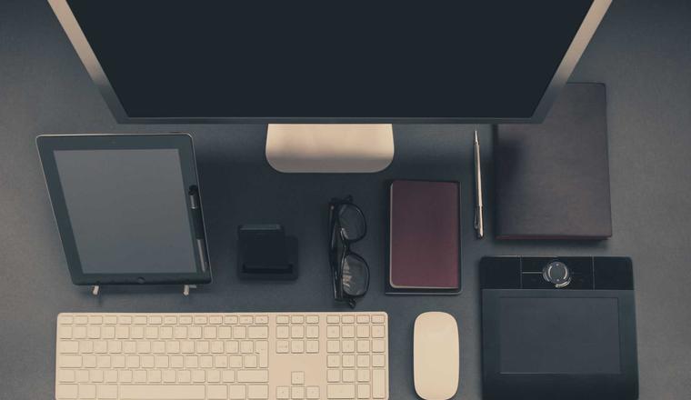 A desk with monitor, tablet and keyboard